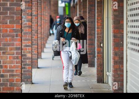 Londra, Regno Unito - 3 novembre 2020 - una giovane donna che indossa una maschera mentre si acquista al mercato di Walthamstow Foto Stock