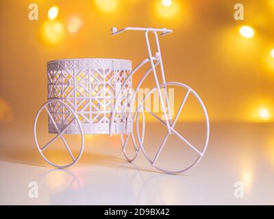 triciclo decorativo con un cesto sullo sfondo di sfocato luci Foto Stock