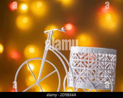 triciclo decorativo con un cesto sullo sfondo di sfocato luci Foto Stock