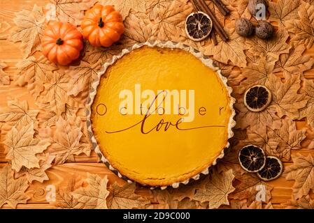vista dall'alto della torta di zucca con decorazione autunnale nei pressi di ottobre scritta amore su sfondo di legno Foto Stock