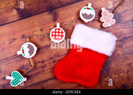 Piatto di Natale di una piccola calza vuota e stagionale clip decorativa su forme su sfondo rustico in legno Foto Stock