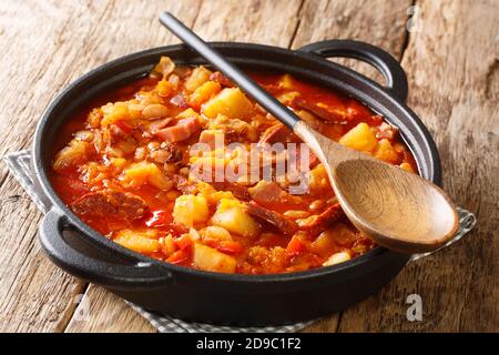 Farro stufato di zucca, fagioli, mais, patate, salsicce e carne primo piano in una pentola sul tavolo. Orizzontale Foto Stock