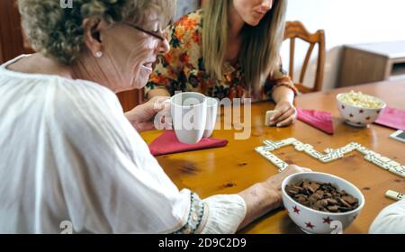 Madre e figlia senior che giocano a domino Foto Stock