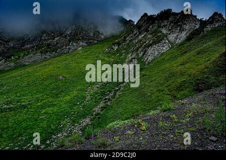 Paesaggio di montagna. Verdi montagne di Aibga cresta e pioggia cielo nuvoloso. Trekking in montagna, stile di vita attivo, spazio minerario, sfondo naturale Foto Stock