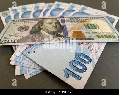 Liras turchi e cento dollari americani. La lira turca si devaluta contro il dollaro americano Foto Stock