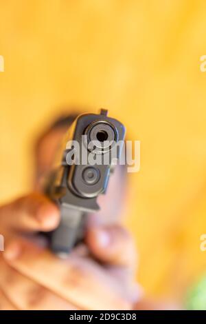 Un uomo punta la sua pistola semiautomatica. Foto Stock