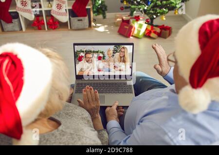 Nonni in Santa caps video che chiamano la loro famiglia a vedere Piccolo nipote il giorno di Natale Foto Stock