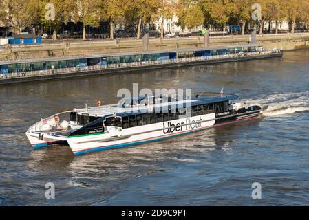 Uber barca sul Tamigi, Londra, Regno Unito. Venus Clipper si avvicina al molo di Westminster Millennium presso il Victoria Embankment con alberi d'autunno Foto Stock