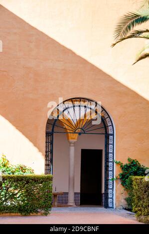 Porta aperta al cortile esterno del Royal Alcázar di Siviglia, Spagna, immerso nella luce e nell'ombra. Foto Stock