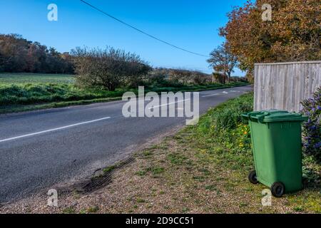 Cestino di riciclaggio verde fuori di una proprietà rurale in attesa di raccolta. Foto Stock