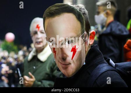 Un protetore che indossa una maschera con un volto del presidente della Polonia Andrzej Duda con luci rosse come simbolo dello Sciopero delle Donne sulle sue guance. Il po Foto Stock