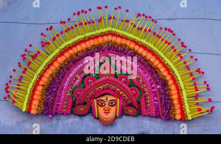 Una maschera Chhau di grandi dimensioni della dea Durga è visualizzata sul muro. Foto Stock