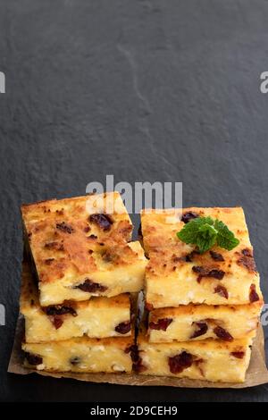 Casetta casereccia formaggio fette di casseruola su sfondo di pietra nera Foto Stock