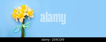 Bouquet di narcisi. Fiori gialli su sfondo blu. Sto aspettando la primavera. Felice cartolina eterna. Disposizione piatta, vista dall'alto Foto Stock
