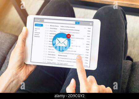 Notifica della posta in arrivo con la donna che riceve un nuovo messaggio a casa su un tablet digitale, concetto di marketing di comunicazione e-mail Foto Stock