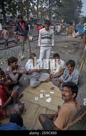 Kolkata, India, gennaio 2008. Persone che giocano carte in una baraccopoli vicino alle piste del treno. Foto Stock