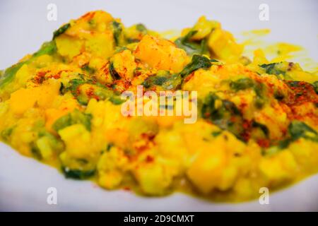 Primo piano di curry in polvere sull'insalata fatta di lattuga e mango Foto Stock
