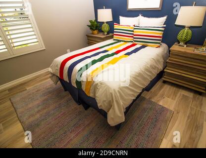 Camera da letto con letto colorato, supporti e lampade da tavolo Foto Stock