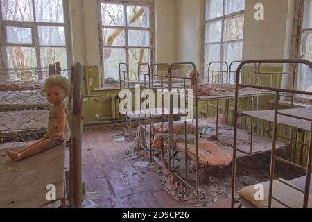 Letti per bambini in un asilo abbandonato. L'interno di un locale in uno degli edifici della zona di esclusione radioattiva di Chernobyl. Foto Stock