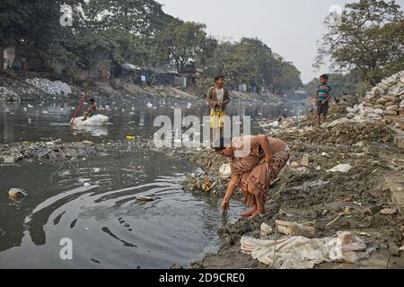 Kolkata, India, gennaio 2008. Persone in un ghat di un canale fortemente inquinato in una baraccopoli di Kalighat. Foto Stock