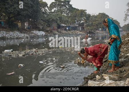 Kolkata, India, gennaio 2008. Persone in un ghat di un canale fortemente inquinato in una baraccopoli di Kalighat. Foto Stock