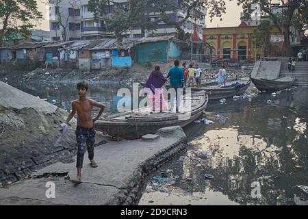 Kolkata, India, gennaio 2008. Persone che attraversano un canale fortemente inquinato in una baraccopoli di Kalighat con un ponte di barche. Foto Stock