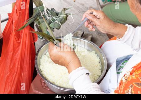 Persona che prepara tradizionale cinese gnocchi o bak chang Foto Stock