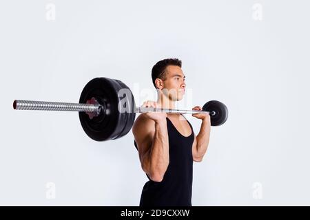 Profilo ritratto vista laterale del suo bel contenuto attraente sportivo forte intenzionale ragazzo messo a fuoco facendo esercizio di sollevamento corpo barbell scolpisci Foto Stock