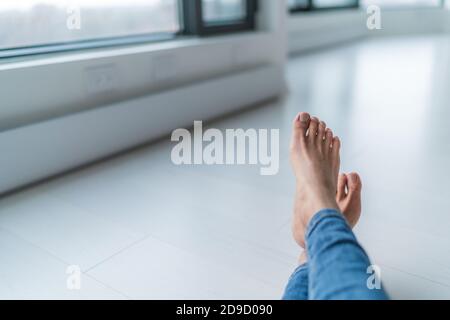 Casa relax comfort lifestyle donna a piedi nudi relax a radiatori caldi sistema di calore in appartamento o condominio vita. Accoglienti baseboards elettriche invernali Foto Stock
