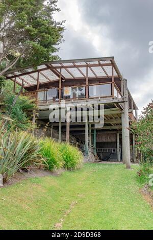 AUCKLAND, NUOVA ZELANDA - 16 novembre 2019: Auckland / Nuova Zelanda - 16 2019 novembre: Vista della pole house sul lato della scogliera di arenaria a Shelly Beach Foto Stock