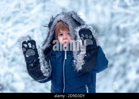 Carino bambino in inverno parco alberi coperto di neve. Inverno bambini tempo libero. Ricordi d'infanzia - bel inverno innevato su prato. Foto Stock