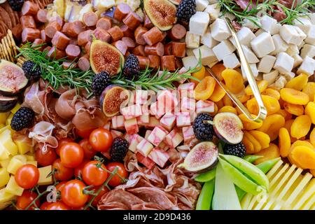 Tavolo con varietà o assortimento di formaggi, frutta e deli. Primo piano. Foto Stock
