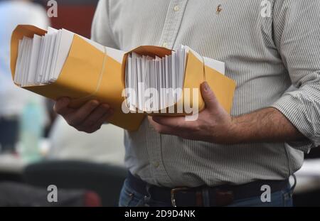 Wilkes barre, Stati Uniti. 04Nov 2020. Il dipendente tiene pacchetti di voti mail-in da conteggiare.Pennsylvania mail-in vengono contati con circa cinquantamila in totale, Luzerne County spera di finire questa sera. I media sono autorizzati a documentare il processo di conteggio dei voti in Pennsylvania. Credit: SOPA Images Limited/Alamy Live News Foto Stock