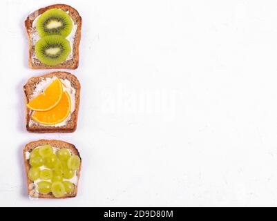 Panini sani alla frutta con formaggio cremoso su sfondo bianco spazio di copia Foto Stock