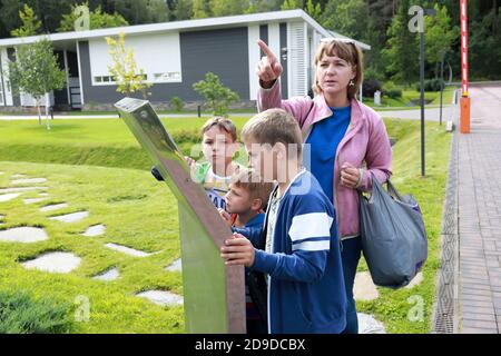 Madre e figli guardano la mappa del parco in estate Foto Stock