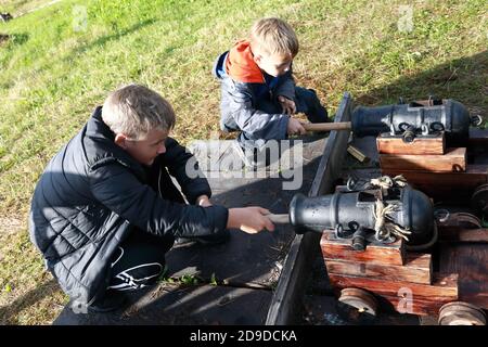 I ragazzi caricano antichi cannoni di segnale in estate Foto Stock