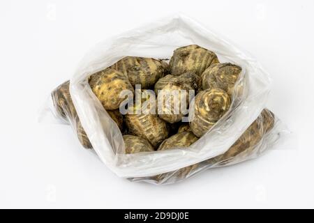 Carciofo di gerusalemme fresco organico all'interno di polietilene bianco trasparente isolato su sfondo bianco Foto Stock