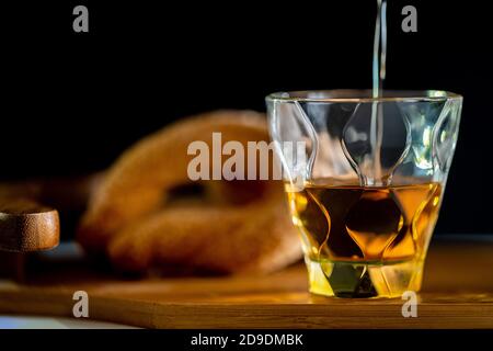 Versare il whisky in bicchiere di whisky su un tavolo di legno. Foto Stock