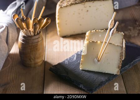 Formaggio semi-stagionato con un sottile strato di erbe aromatiche. Tipico spuntino della cucina mediterranea Foto Stock