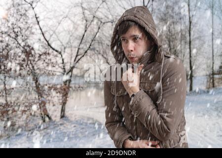 L'uomo si sta congelando all'aperto in inverno freddo. Foto Stock