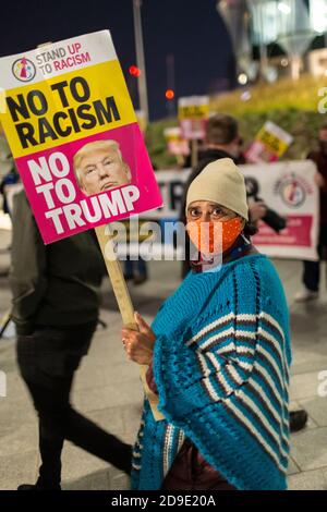 Ritratto di una donna in maschera facciale che tiene un cartello durante una dimostrazione anti-Trump, ambasciata degli Stati Uniti, Londra, 4 novembre 2020 Foto Stock