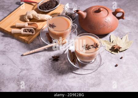 Tè indiano masala tè. Tè con latte e spezie in cucchiai di legno. Orientamento orizzontale Foto Stock