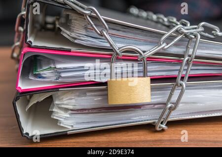 Concetto di privacy e sicurezza. File e documenti riservati in rilegatore con lucchetto e catena. Foto Stock