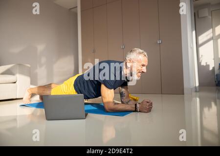 Maschio eccitato che fa una presa anteriore in una stanza soleggiata Foto Stock