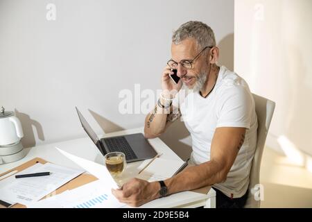 Uomo impegnato a fare una telefonata su un giornale ufficiale Foto Stock