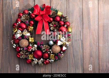 Corona di Natale su sfondo di legno. Decorazioni natalizie fatte a mano Foto Stock