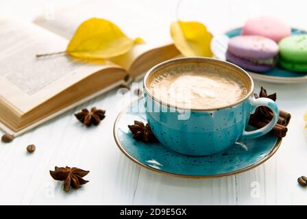 Tazza da caffè, macaron e libro su sfondo bianco Foto Stock