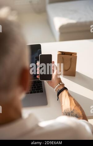 Adulto che tiene un cellulare di fronte a lui Foto Stock