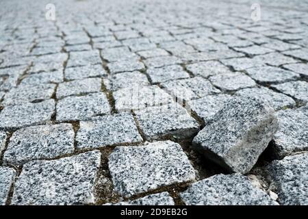 Un solo ciottolo fuori dalla struttura su una strada acciottolata in una vecchia città medievale. Viale grigio lastricato di pietre. Mosaico del sentiero urbano Foto Stock