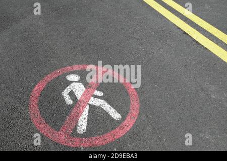 Segnale di marcatura stradale bianco e linee gialle su asfalto in cemento. Restrizioni di trasporto durante il tragitto. Non sono ammessi pedoni, non è consentito camminare, guidare e. Foto Stock